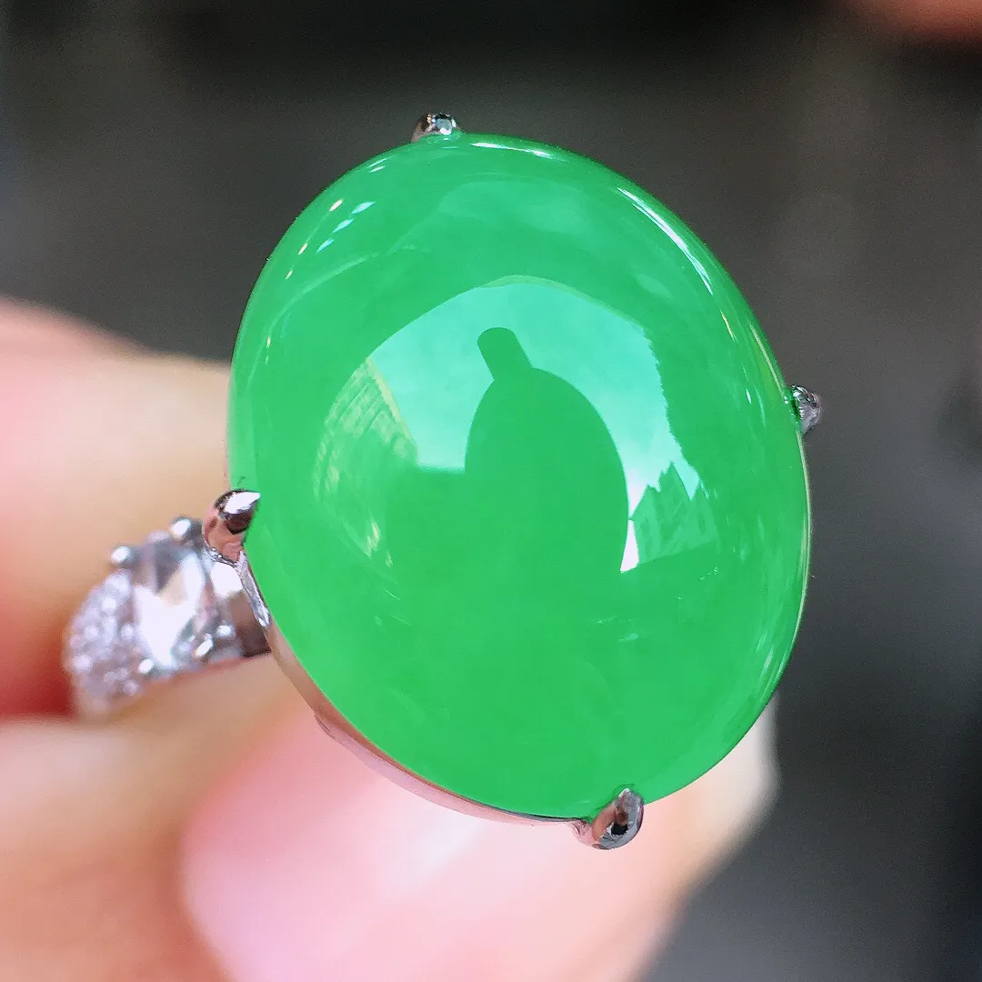 阳绿蛋面戒指，色泽均匀艳丽，玉质细腻，荧光感超
强，饱满圆润，尽显优雅气质，18k
金豪华镶嵌