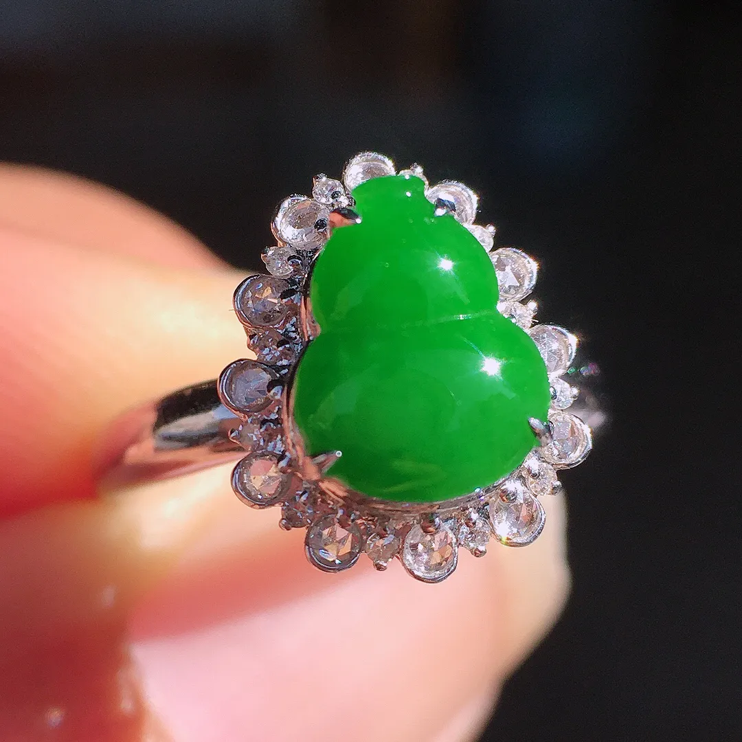 阳绿葫芦戒指，色泽均匀艳丽，玉质细腻，荧光感超
强，饱满圆润，尽显优雅气质，18k
金豪华镶嵌