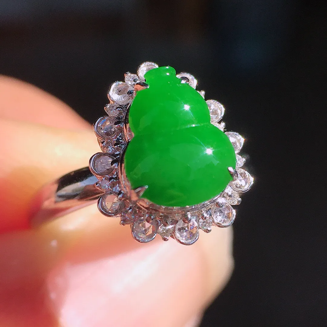 阳绿葫芦戒指，色泽均匀艳丽，玉质细腻，荧光感超
强，饱满圆润，尽显优雅气质，18k
金豪华镶嵌