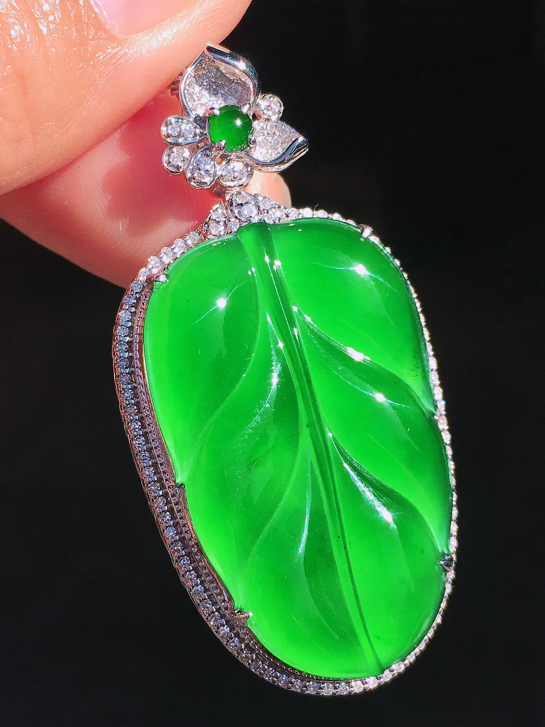 阳绿玉叶吊坠，色泽均匀艳丽，玉质细腻，荧光感超
强，饱满圆润，尽显优雅气质，18k
金豪华镶嵌