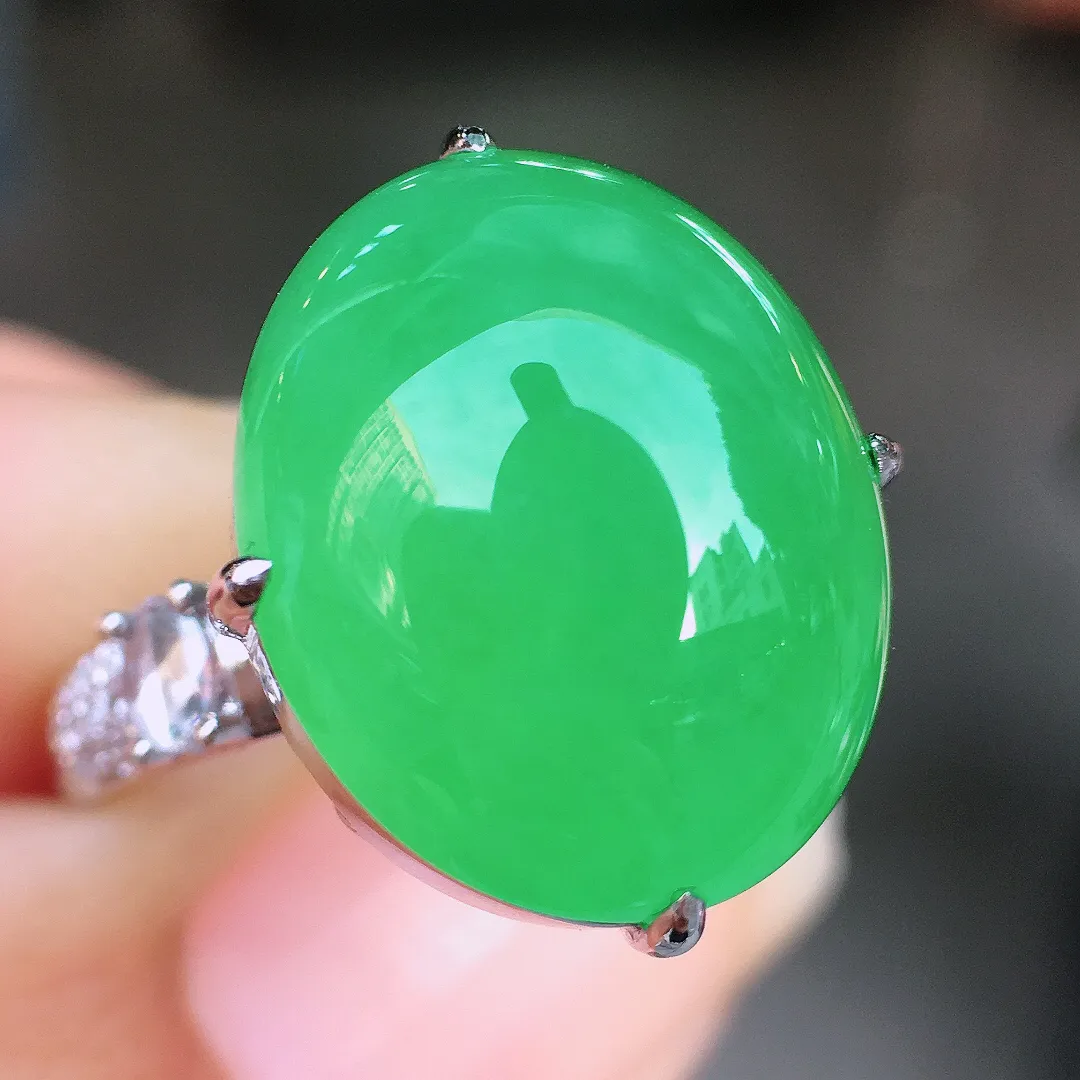 阳绿蛋面戒指，色泽均匀艳丽，玉质细腻，荧光感超
强，饱满圆润，尽显优雅气质，18k
金豪华镶嵌