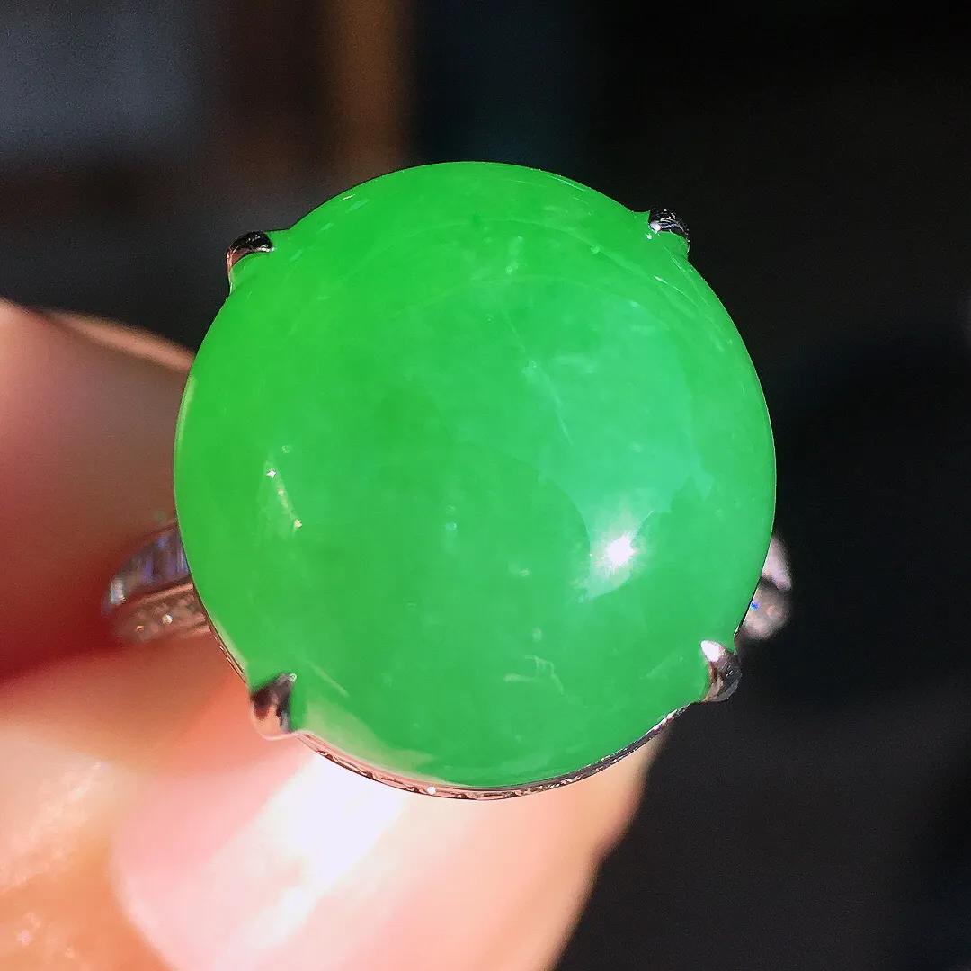 阳绿蛋面戒指，色泽均匀艳丽，玉质细腻，荧光感超
强，饱满圆润，尽显优雅气质，18k
金豪华镶嵌