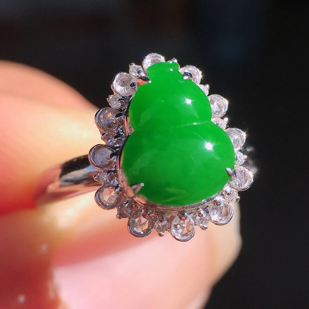 阳绿葫芦戒指，色泽均匀艳丽，玉质细腻，荧光感超
强，饱满圆润，尽显优雅气质，18k
金豪华镶嵌