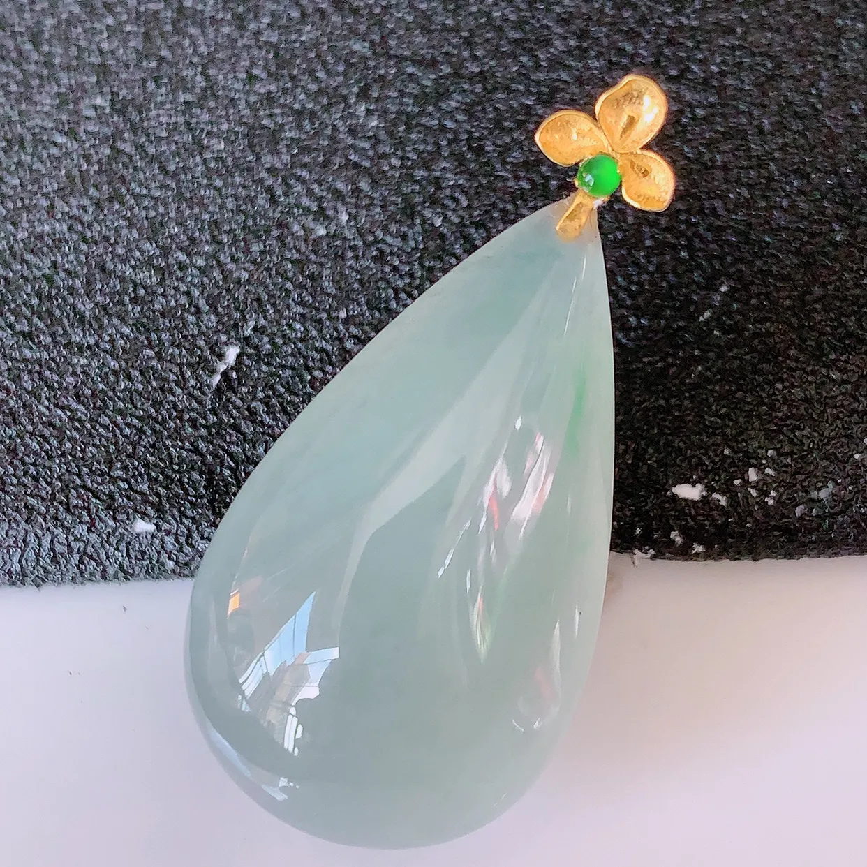 18K金镶嵌冰种飘绿翡翠水滴吊坠，品相佳，颜色漂亮，佩戴时尚优雅，尽显气质。水滴寓意“水滴聚财，坚持不懈，如水爱心” #94.27