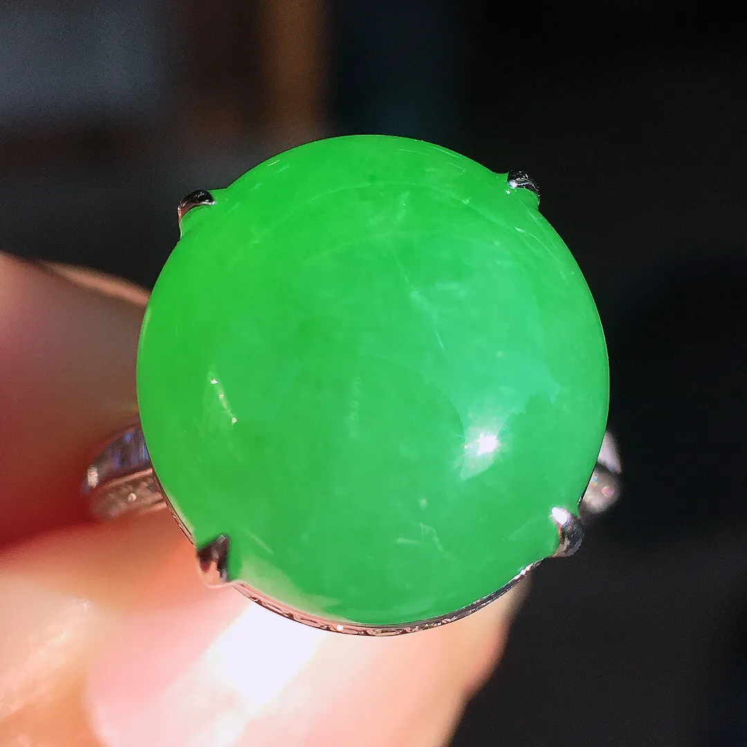 阳绿蛋面戒指，色泽均匀艳丽，玉质细腻，荧光感超
强，饱满圆润，尽显优雅气质，18k
金豪华镶嵌