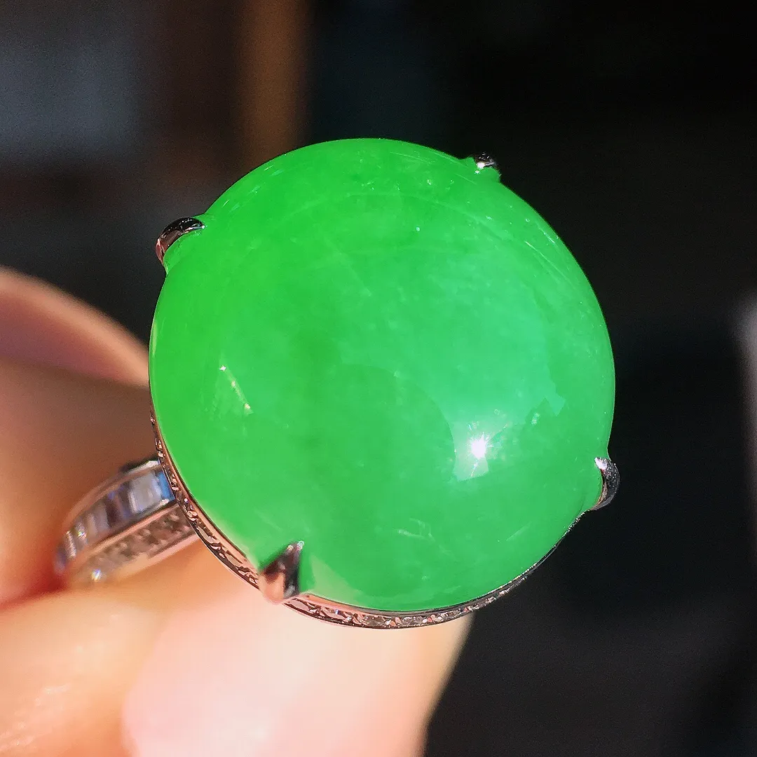 阳绿蛋面戒指，色泽均匀艳丽，玉质细腻，荧光感超
强，饱满圆润，尽显优雅气质，18k
金豪华镶嵌