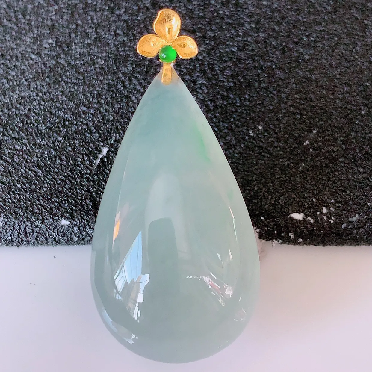 18K金镶嵌冰种飘绿翡翠水滴吊坠，品相佳，颜色漂亮，佩戴时尚优雅，尽显气质。水滴寓意“水滴聚财，坚持