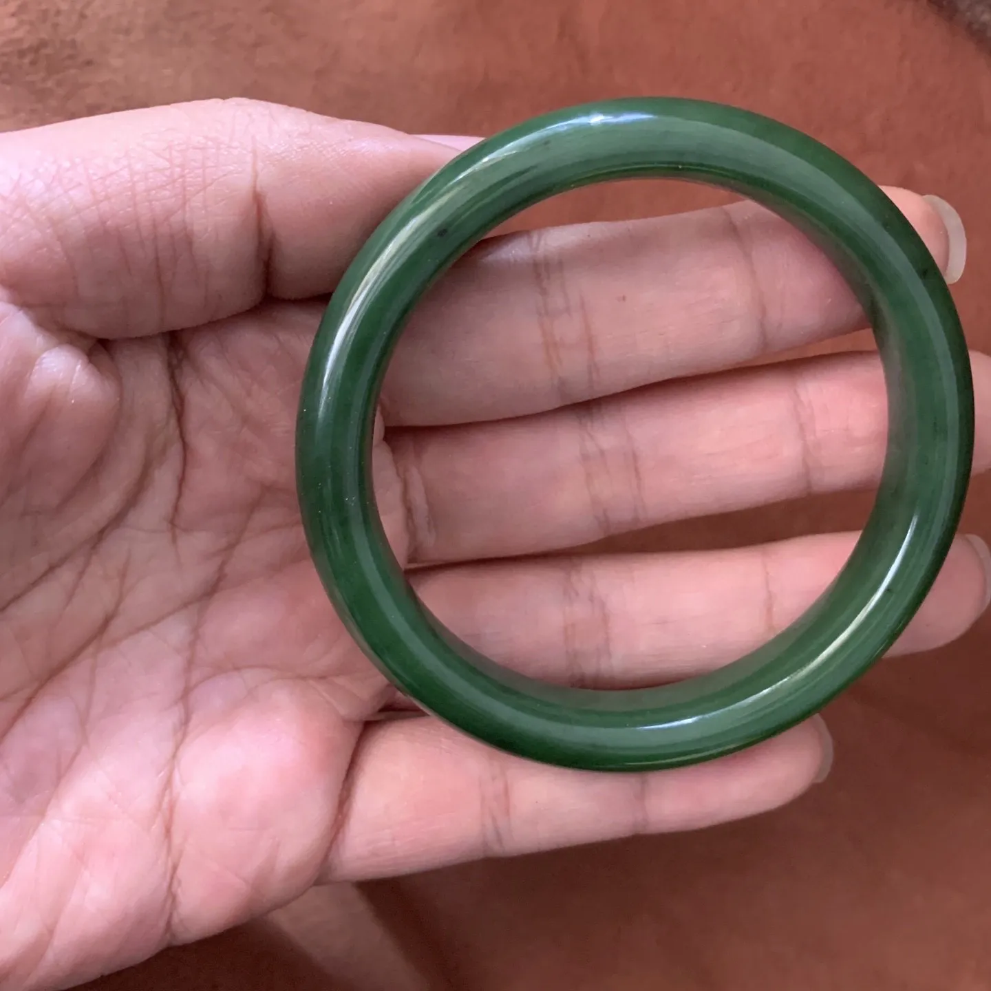 59.5圈口和田玉碧玉菠菜绿手镯【挽间柔情】，和田玉59.5圈口菠菜绿手镯，镯型古朴典雅。在诗情画意的雨巷相遇，你是我腕间的一抹风情，有你眸有深情.清风荡漾湖间静水，我愿俯身低眉，在烟波涟漪处寻。