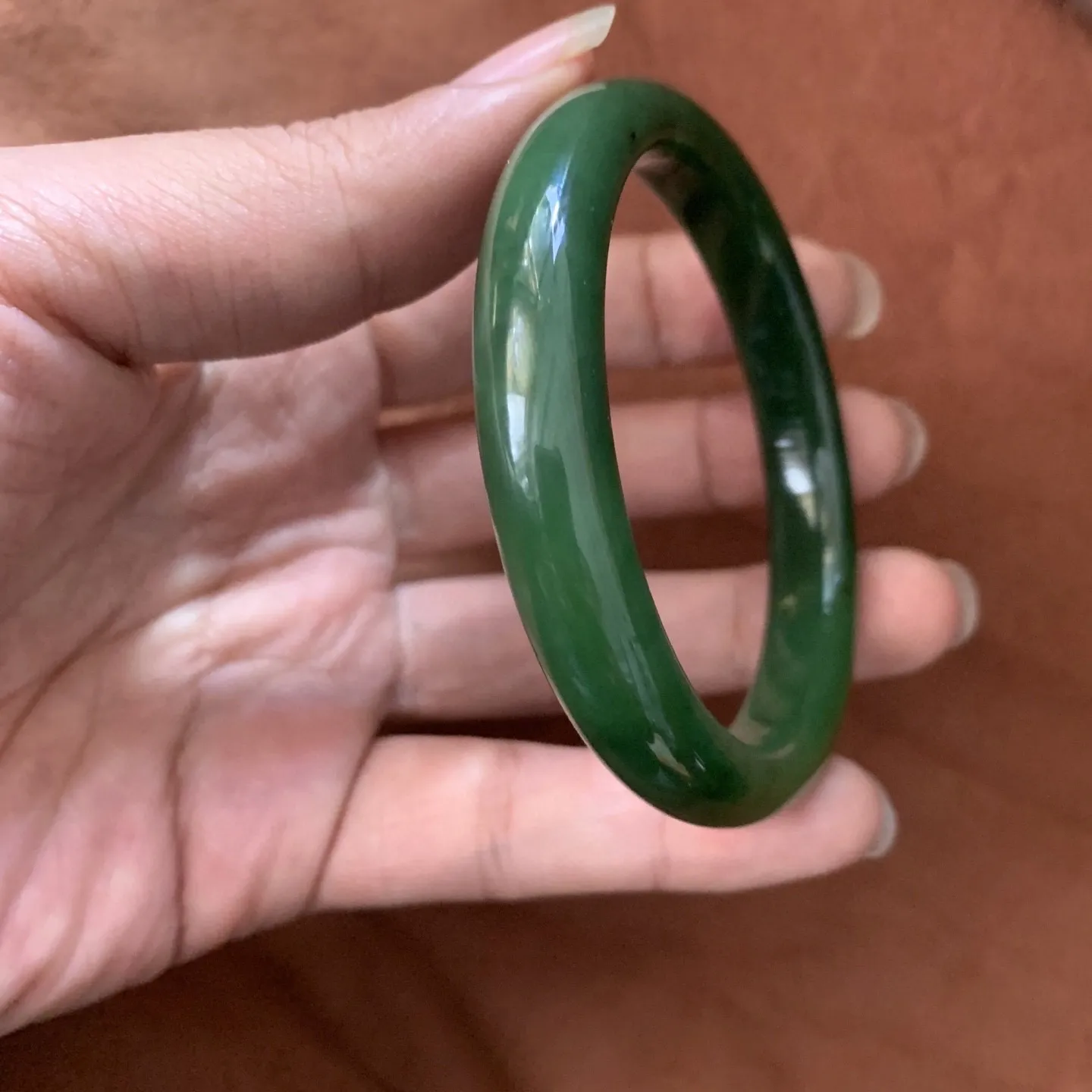 59.5圈口和田玉碧玉菠菜绿手镯【挽间柔情】，和田玉59.5圈口菠菜绿手镯，镯型古朴典雅。在诗情画意的雨巷相遇，你是我腕间的一抹风情，有你眸有深情.清风荡漾湖间静水，我愿俯身低眉，在烟波涟漪处寻。