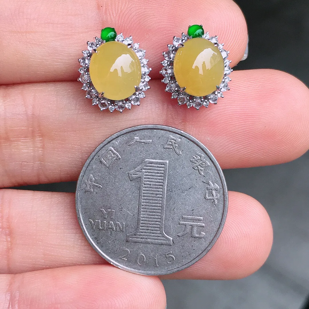 黄翡蛋面耳钉，色泽均匀艳丽，玉质细腻，荧光感超
强，饱满圆润，尽显优雅气质，18k
金豪华镶嵌