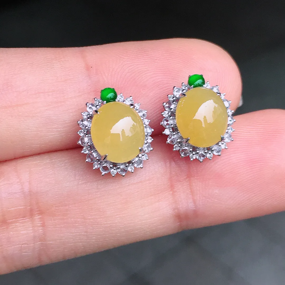 黄翡蛋面耳钉，色泽均匀艳丽，玉质细腻，荧光感超
强，饱满圆润，尽显优雅气质，18k
金豪华镶嵌