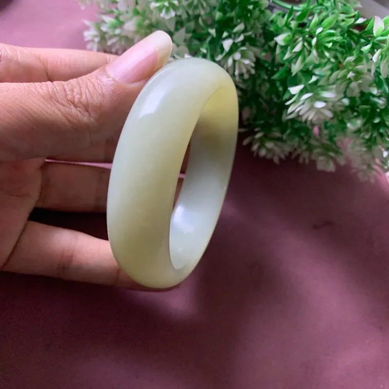 和田玉57圈口黄口料宽版手镯，玉质特细腻油润，高脂粉，品相超赞，萦绕腕间时，古韵不失时尚，素雅不失品味，细腻光滑的触感，使人沉醉，气质高