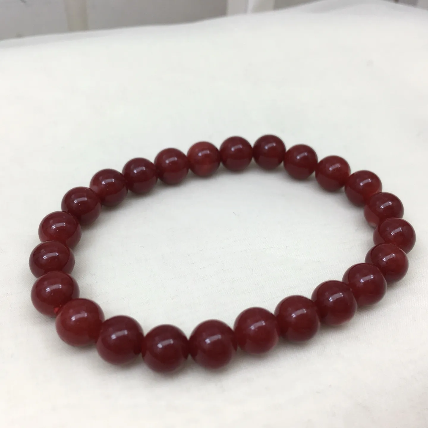 【天然日本阿卡牛血红珊瑚7.4mm圆珠弹力单手串】难得高瓷度，日本产地，阿卡材料，整条少虫眼少白芯的阿卡圆珠。整条赤血牛血红颜色，珠子直径7.4-7mm，每颗珠子均为天然的珊瑚，珊瑚自古就为佛教珍宝，深海千年有机宝石！收藏价值高、可传承重量为12.95克！追求品质者的福音！实物漂亮！