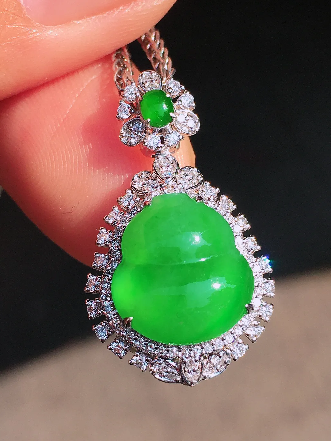 阳绿葫芦吊坠，色泽均匀艳丽，玉质细腻，荧光感超
强，饱满圆润，尽显优雅气质，18k
金豪华镶嵌