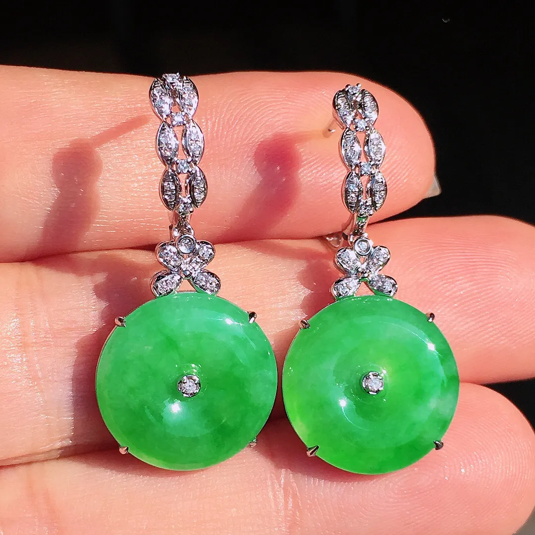 阳绿平安扣耳坠，色泽均匀艳丽，玉质细腻，荧光感超
强，饱满圆润，尽显优雅气质，18k
金豪华镶嵌