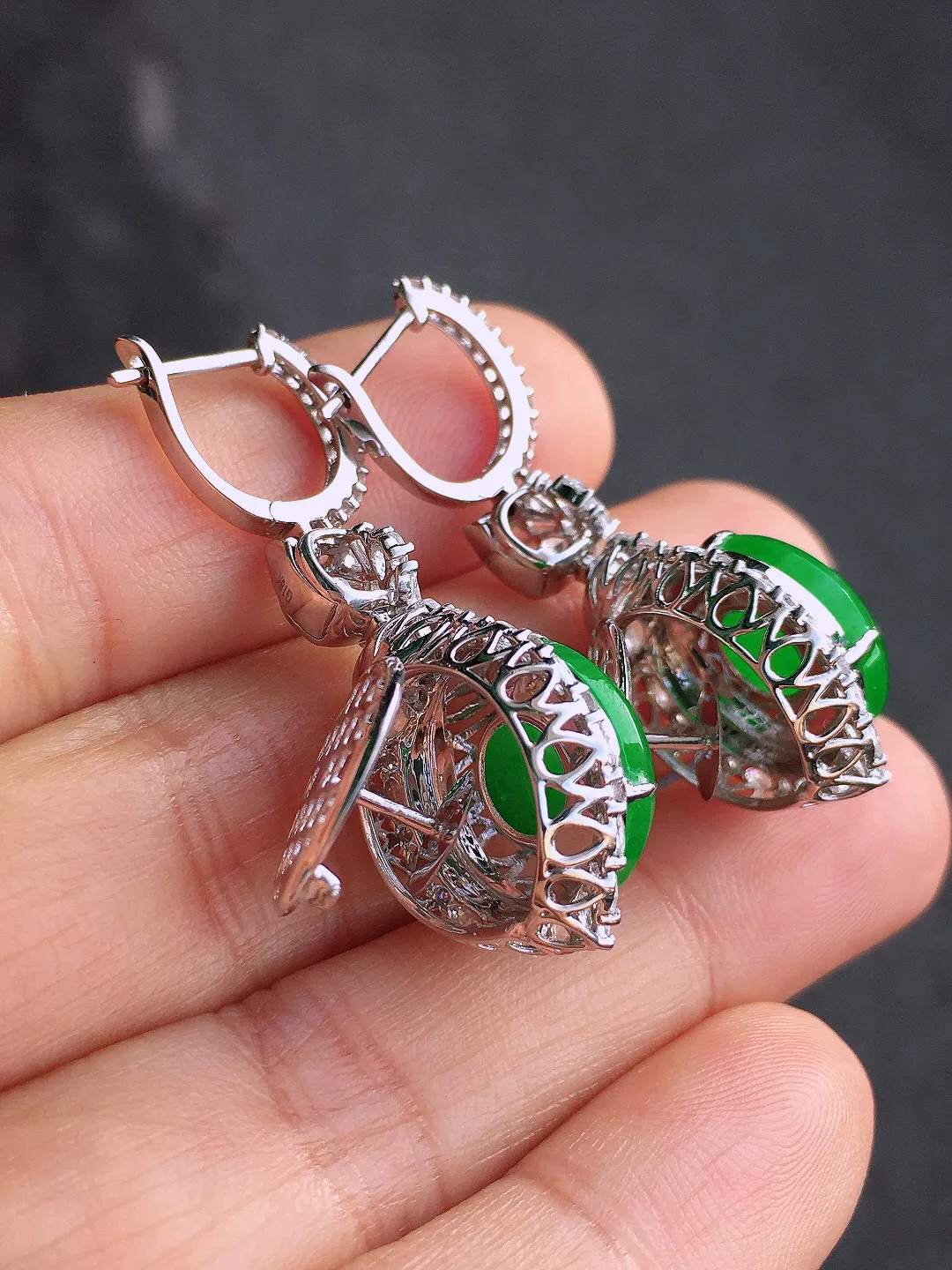 阳绿平安扣耳坠，色泽均匀艳丽，玉质细腻，荧光感超
强，饱满圆润，尽显优雅气质，18k
金豪华镶嵌