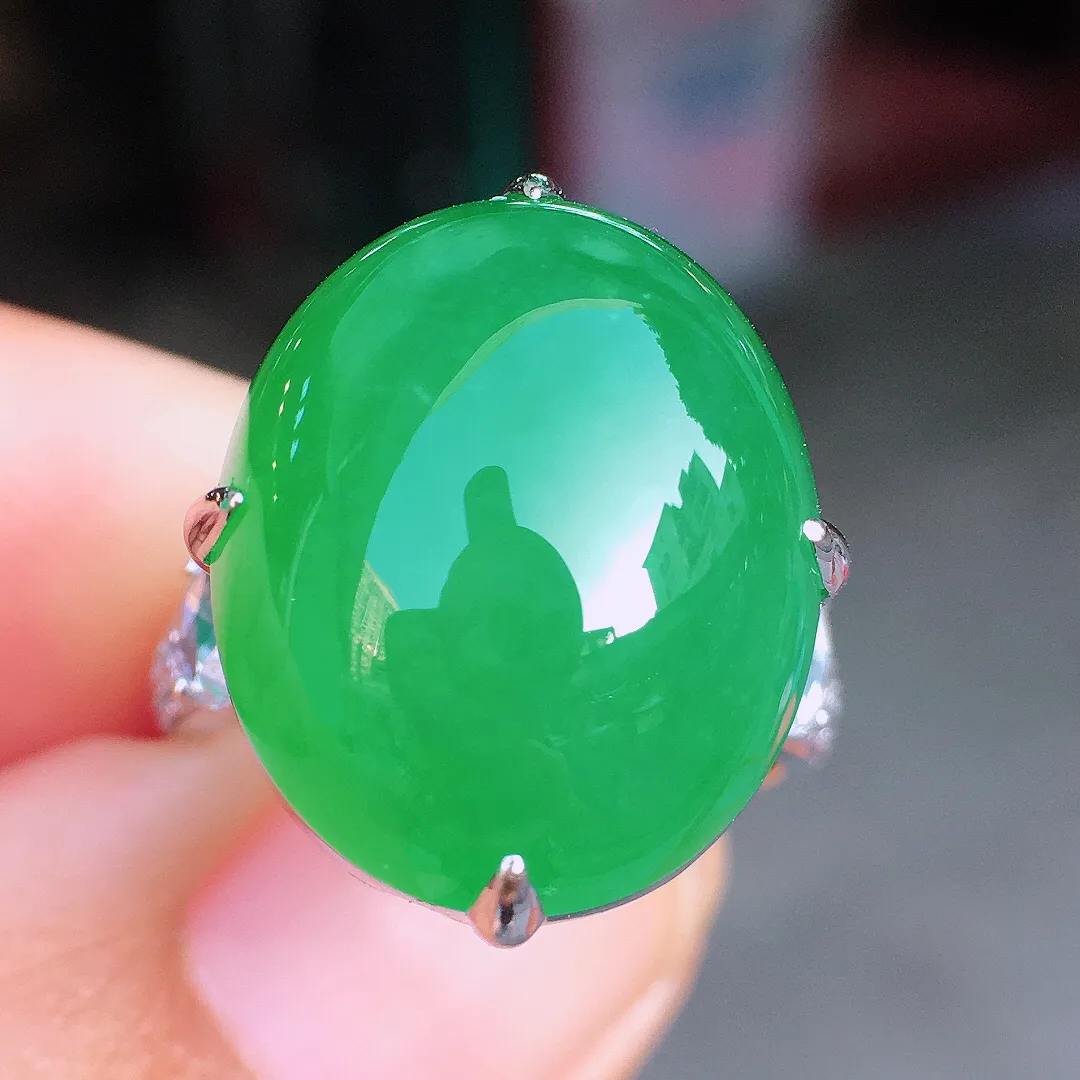 阳绿蛋面戒指，色泽均匀艳丽，玉质细腻，荧光感超
强，饱满圆润，尽显优雅气质，18k
金豪华镶嵌