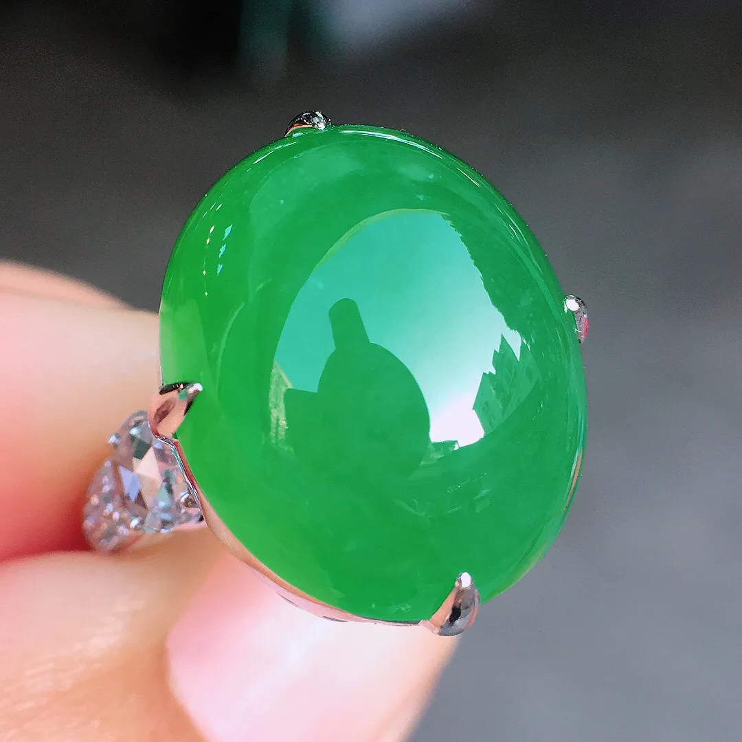 阳绿蛋面戒指，色泽均匀艳丽，玉质细腻，荧光感超
强，饱满圆润，尽显优雅气质，18k
金豪华镶嵌