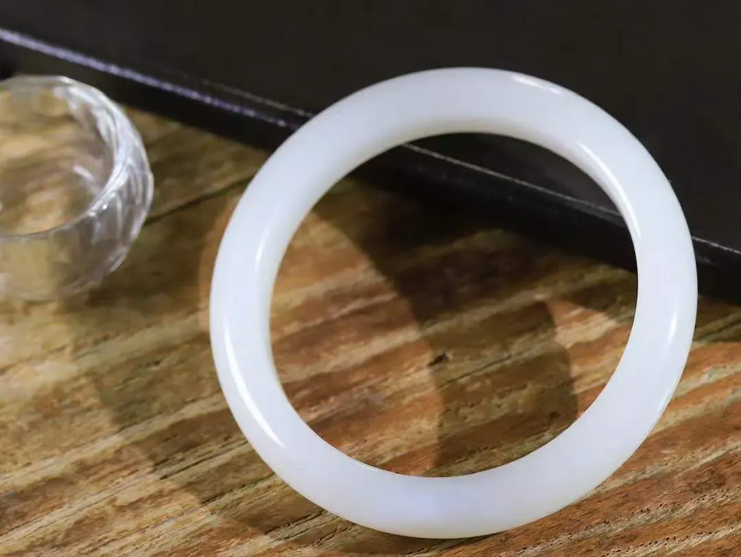 【柔情素语·手镯】

精品和田玉白玉手镯，玉质细腻温润，手感舒适，️线条流畅，简约大气，美自天成，佩戴于腕间，婉约之美，举手投足间透出那份低调奢华，醉人心扉。重56.4克 内径圈口61mm  尺寸11.9-9mm   FDA-55124800