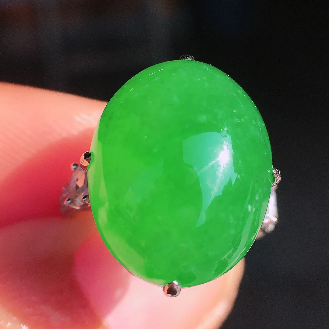 阳绿蛋面戒指，色泽均匀艳丽，玉质细腻，荧光感超
强，饱满圆润，尽显优雅气质，18k
金豪华镶嵌