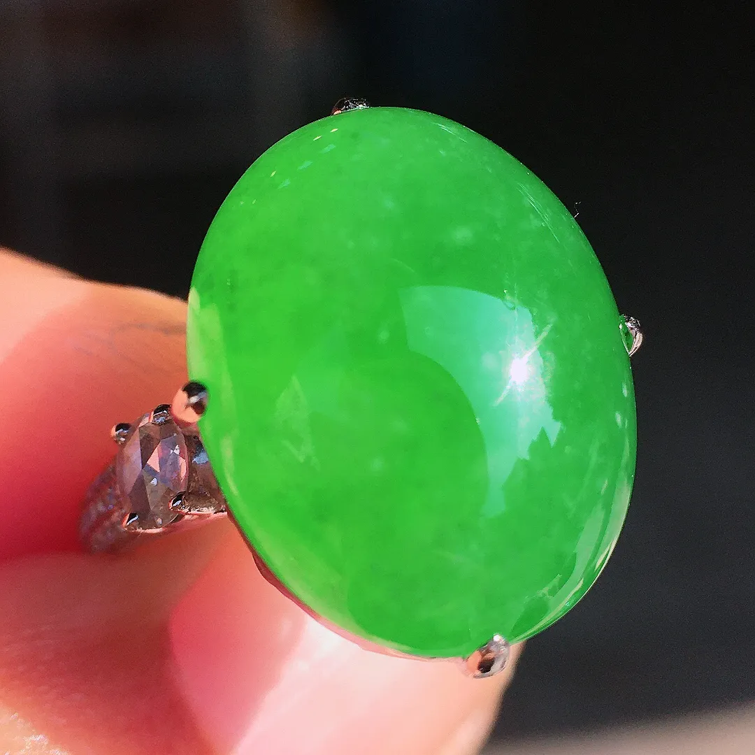 阳绿蛋面戒指，色泽均匀艳丽，玉质细腻，荧光感超
强，饱满圆润，尽显优雅气质，18k
金豪华镶嵌