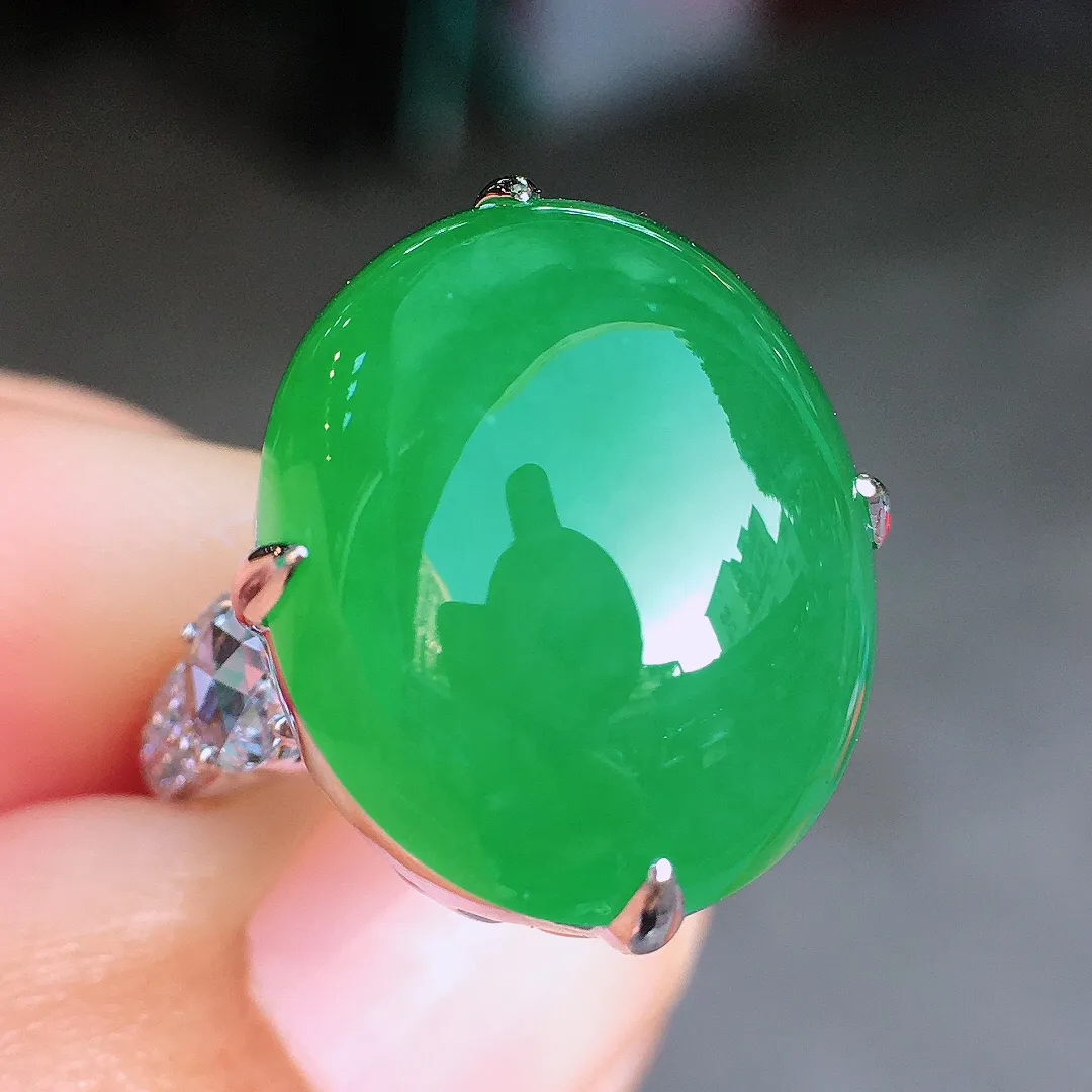 阳绿蛋面戒指，色泽均匀艳丽，玉质细腻，荧光感超
强，饱满圆润，尽显优雅气质，18k
金豪华镶嵌