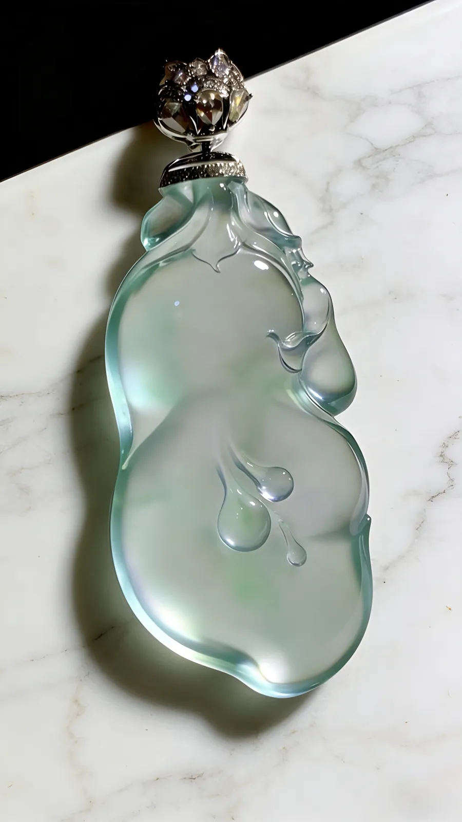 【兰心含芳·玉兰花】。德镔玉雕艺术作品，
玉质质地清透似寒冰，莹润光泽藏不住的温润，随形雕琢的线条婉转灵动，方寸间揽尽翡翠的万般风情。作品52.5裸石43-22-8mm，
18K金，南非钻，13.9g，