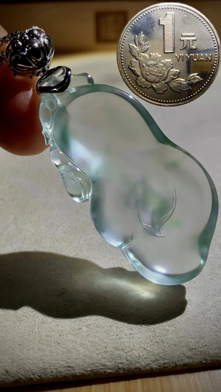 【兰心含芳·玉兰花】。德镔玉雕艺术作品，
玉质质地清透似寒冰，莹润光泽藏不住的温润，随形雕琢的线条婉转灵动，方寸间揽尽翡翠的万般风情。作品52.5裸石43-22-8mm，
18K金，南非钻，13.9g，