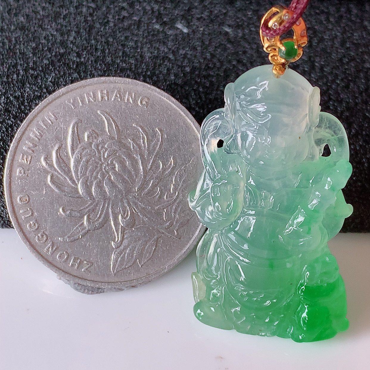 自然光实拍，18K金镶嵌冰种飘绿翡翠不动明王吊坠，不动明王具有在遇到任何困难的时候，均能扫除障难，并不为动摇之意。不动明王显现愤怒像，使侵扰众生之邪魔畏惧而远离，使众生于修行路上不致动摇善念菩提心。生肖属鸡的守护神  佩戴效果优雅迷人！#1.11整体38裸石32*18.5*5.8
