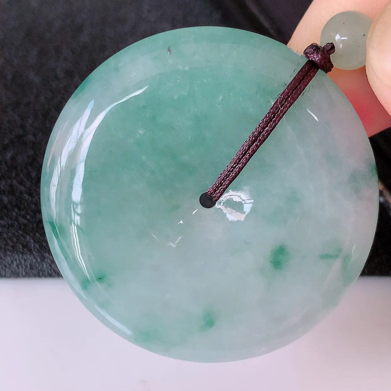 自然光实拍，冰润飘绿翡翠平安扣吊坠，形体饱满圆润，平安扣肥嘟嘟的，平平安安，平安扣种水很好，配戴精美