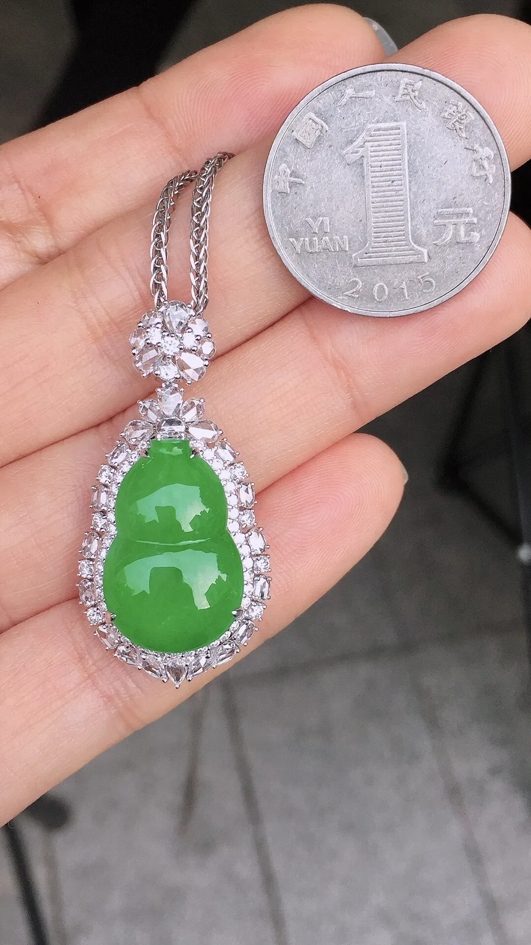 阳绿葫芦吊坠，色泽均匀艳丽，玉质细腻，荧光感超
强，饱满圆润，尽显优雅气质，18k
金豪华镶嵌