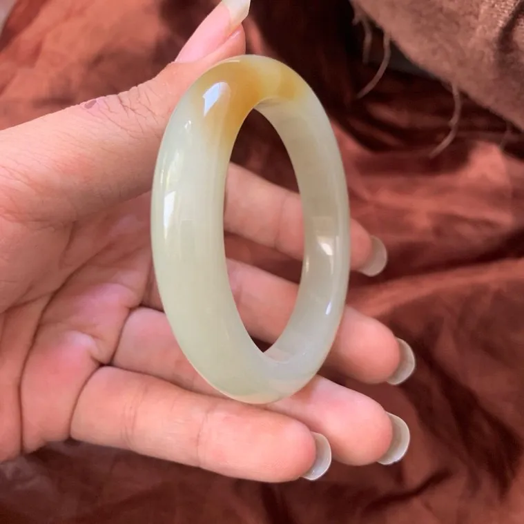 金蜜糖，53.5圈口和田玉且末糖料手镯【挽间柔情】，镯型古朴典雅。在诗情画意的雨巷相遇，你是我腕间的一抹风情，有你眸有深情.清风荡漾湖间静水，我愿俯身低眉，在烟波涟漪处寻你。规格53.5/12.5