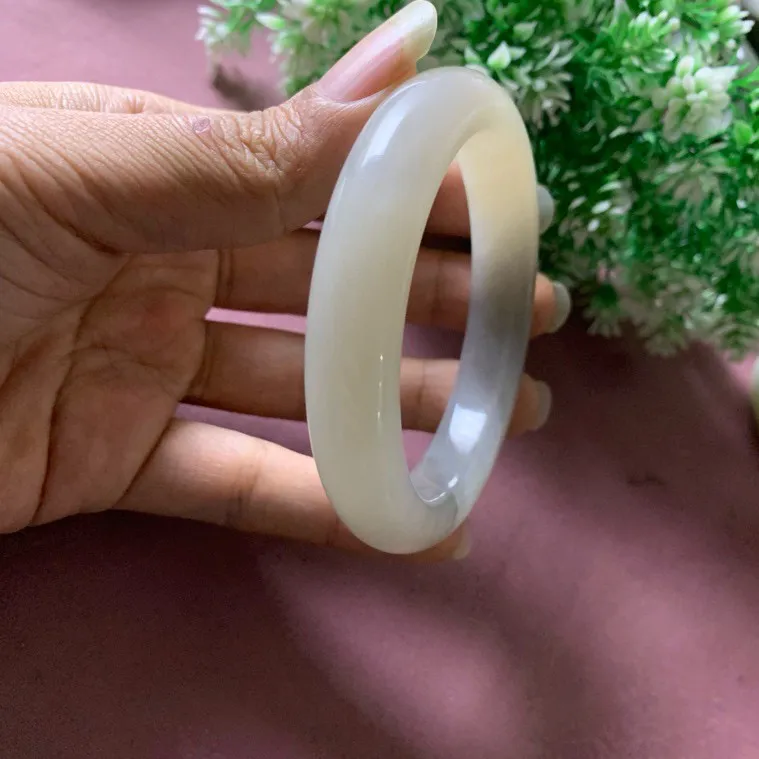 59.5圈口和田玉白加紫色手镯【挽间柔情】，镯型古朴典雅。在诗情画意的雨巷相遇，你是我腕间的一抹风情，有你眸有深情.清风荡漾湖间静水，我愿俯身低眉，在烟波涟漪处寻你。规格59.5/13.5