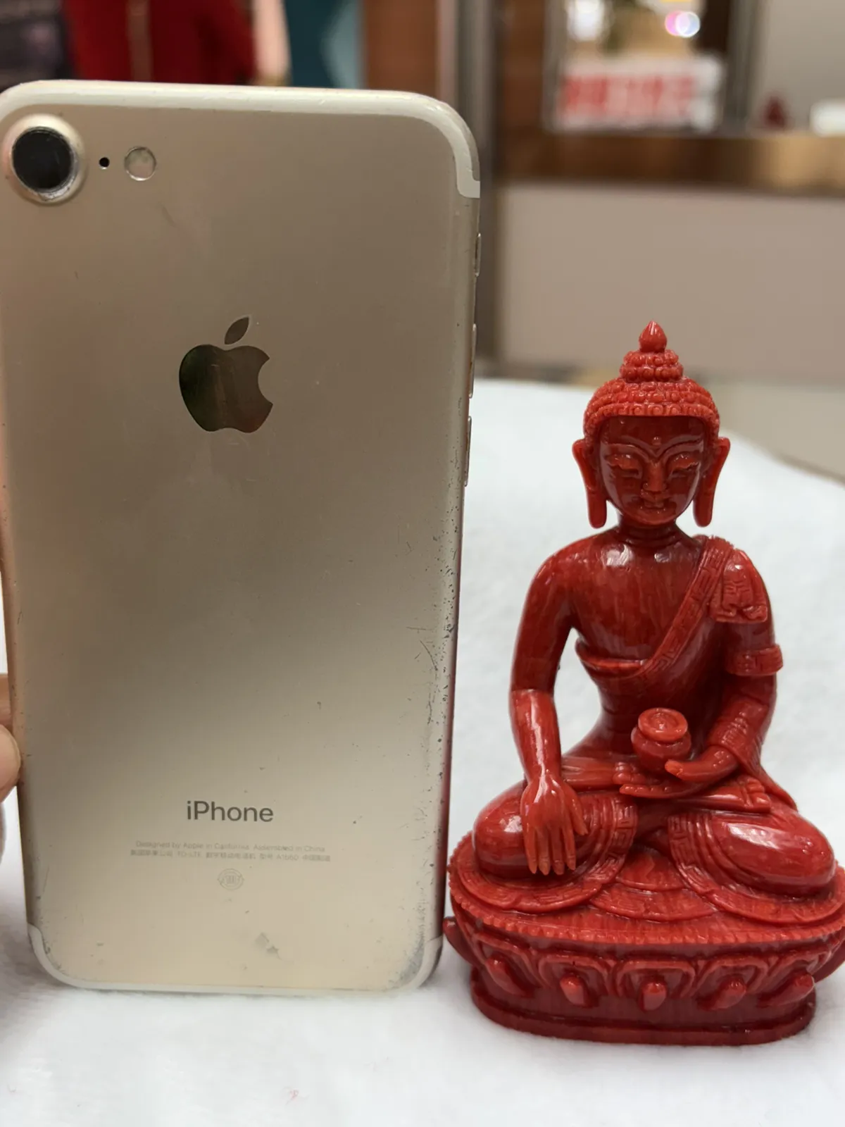 【红珊瑚释迦牟尼佛中号佛像摆件】佛祖庄严肃穆，佛像顶结高肉螺髻，髻顶可见顶严，双耳垂肩，脸型清秀，双眉高挑，高鼻细挺，身着袒右式袈裟，左手持钵，裸双足结跏趺坐于莲台之上，莲台高起，饰有饱满的连珠纹，底部有开孔，可藏经文珠宝等，材料为天然意大利沙丁，台湾拼接工艺，做工精良，裸石尺寸110*63.7*43.6mm，重量120.25克。