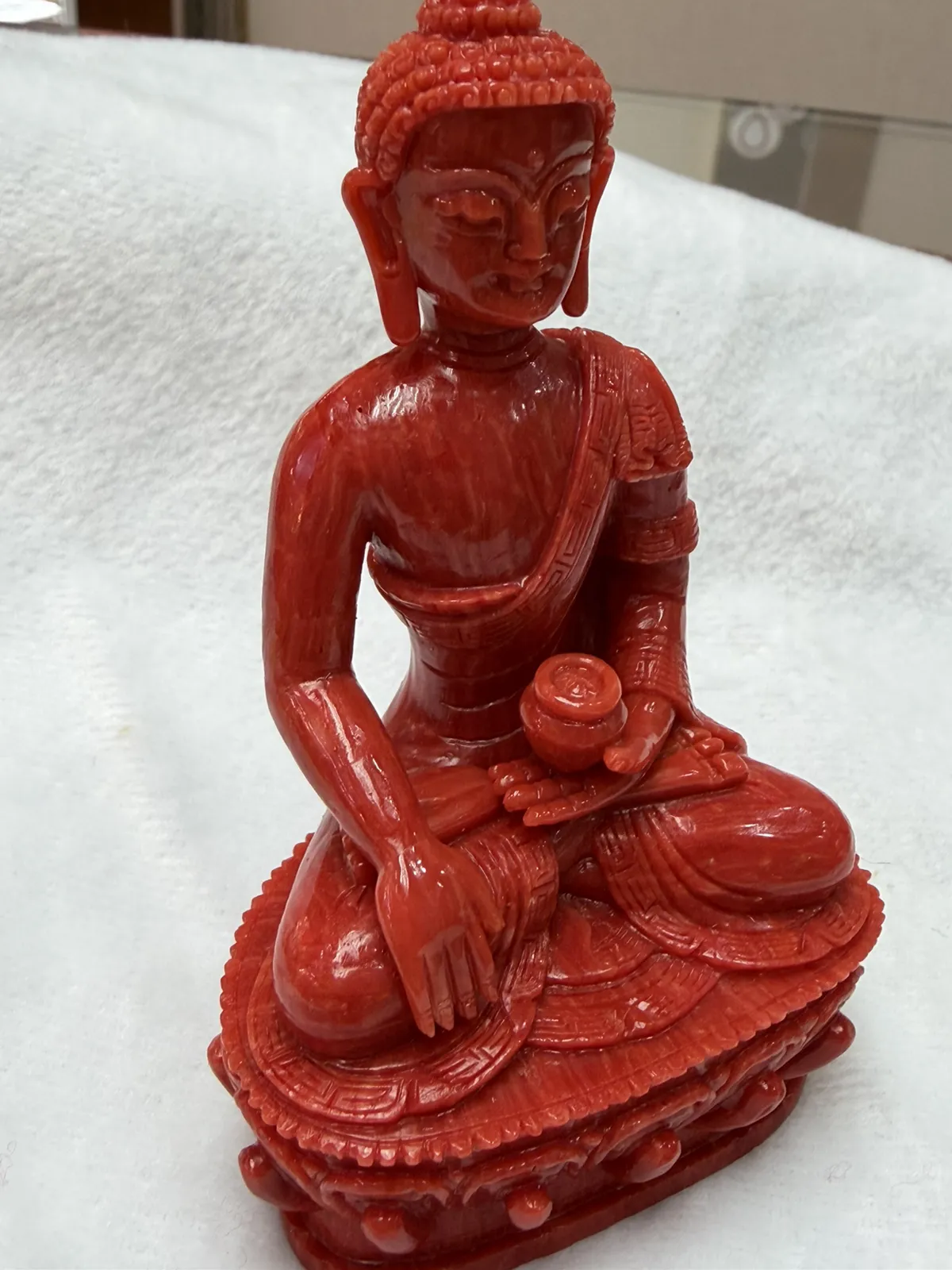 【红珊瑚释迦牟尼佛中号佛像摆件】佛祖庄严肃穆，佛像顶结高肉螺髻，髻顶可见顶严，双耳垂肩，脸型清秀，双眉高挑，高鼻细挺，身着袒右式袈裟，左手持钵，裸双足结跏趺坐于莲台之上，莲台高起，饰有饱满的连珠纹，底部有开孔，可藏经文珠宝等，材料为天然意大利沙丁，台湾拼接工艺，做工精良，裸石尺寸110*63.7*43.6mm，重量120.25克。