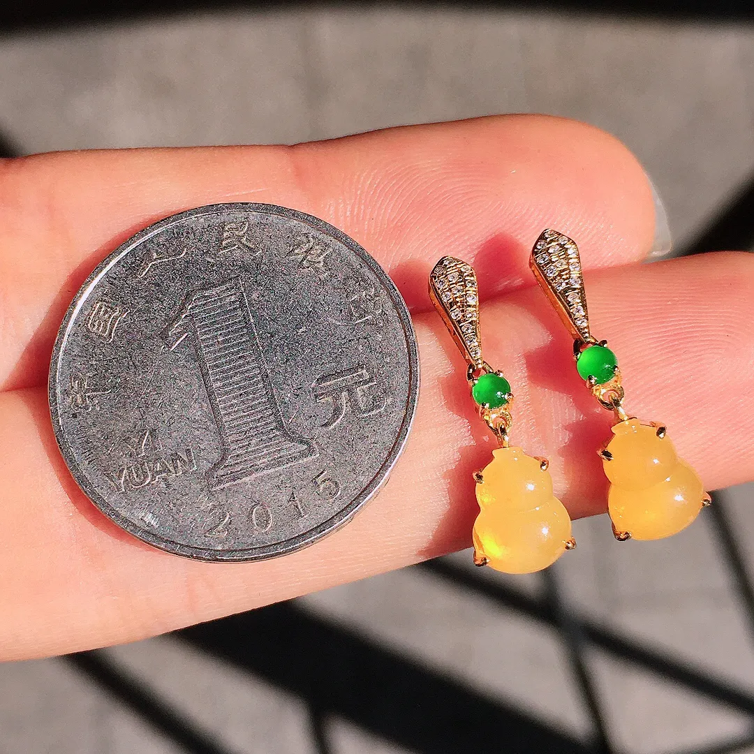 黄翡葫芦耳坠，色泽均匀艳丽，玉质细腻，荧光感超
强，饱满圆润，尽显优雅气质，18k
金豪华镶嵌