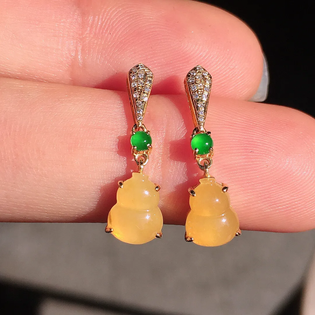 黄翡葫芦耳坠，色泽均匀艳丽，玉质细腻，荧光感超
强，饱满圆润，尽显优雅气质，18k
金豪华镶嵌