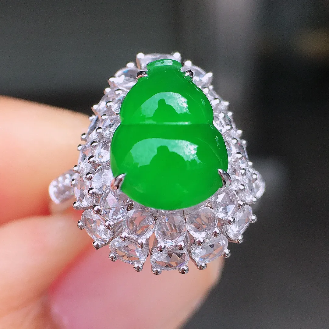 阳绿葫芦戒指，色泽均匀艳丽，玉质细腻，荧光感超
强，饱满圆润，尽显优雅气质，18k
金豪华镶嵌