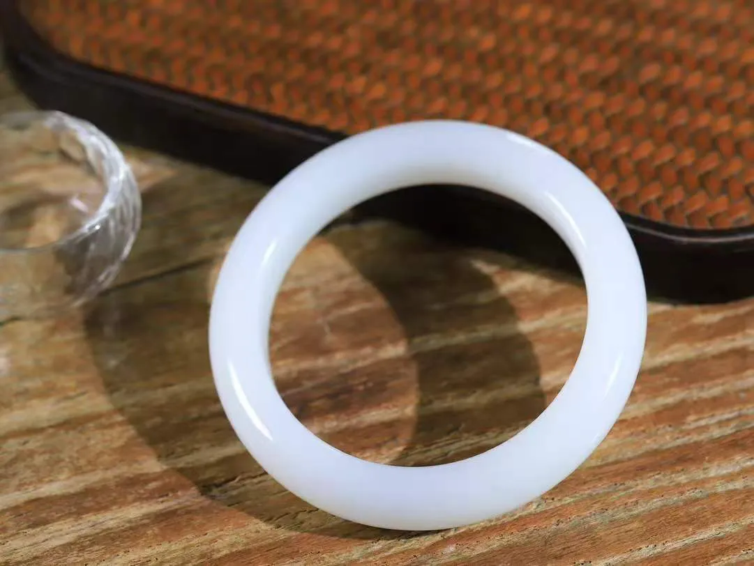 【婉约佳人.手镯】

精品和田玉白玉手镯 玉质温润细腻 油性十足 手感舒适，高华雅逸，线条流畅，简约大气，美自天成，素雅高贵。佩戴于腕间，婉约之美，举手投足间透出那份低调奢华。重61.3克 内径56.5mm  尺寸12.6-9.8mm   FDL-11120733