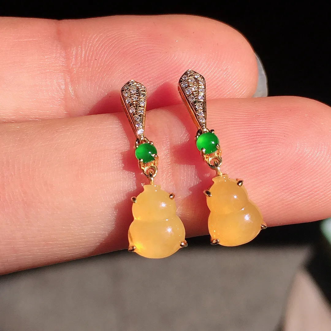 黄翡葫芦耳坠，色泽均匀艳丽，玉质细腻，荧光感超
强，饱满圆润，尽显优雅气质，18k
金豪华镶嵌