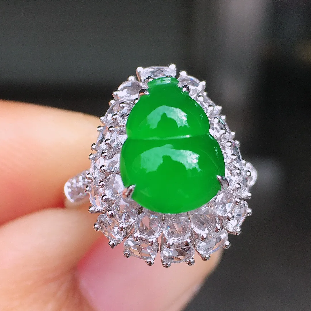 阳绿葫芦戒指，色泽均匀艳丽，玉质细腻，荧光感超
强，饱满圆润，尽显优雅气质，18k
金豪华镶嵌