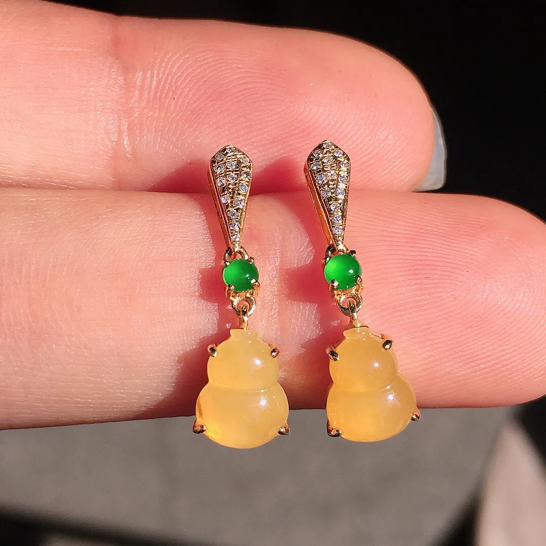 黄翡葫芦耳坠，色泽均匀艳丽，玉质细腻，荧光感超
强，饱满圆润，尽显优雅气质，18k
金豪华镶嵌