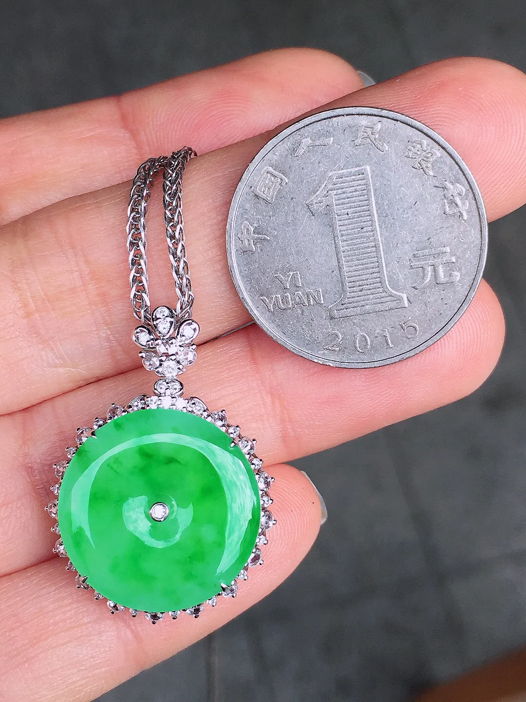 阳绿平安扣吊坠，色泽均匀艳丽，玉质细腻，荧光感超
强，饱满圆润，尽显优雅气质，18k
金豪华镶嵌