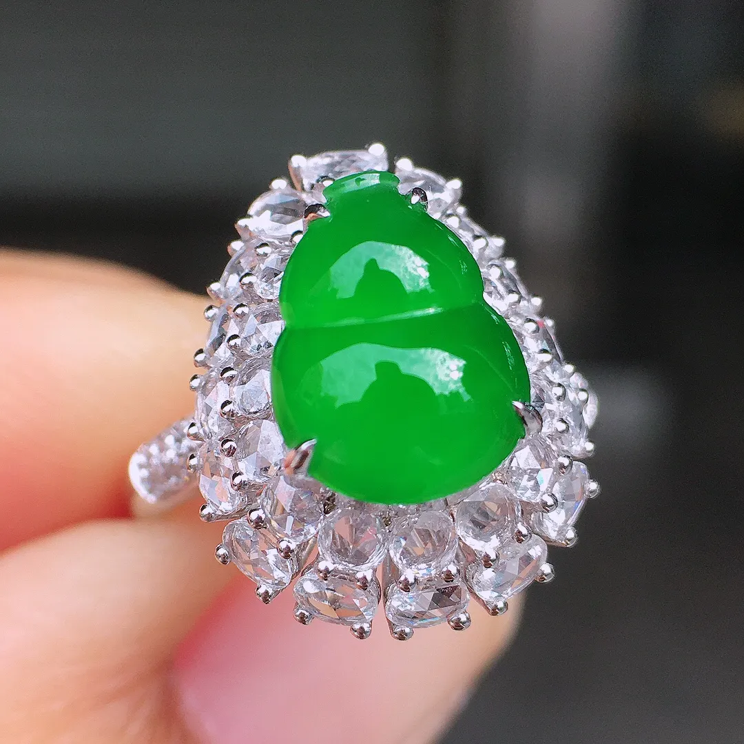 阳绿葫芦戒指，色泽均匀艳丽，玉质细腻，荧光感超
强，饱满圆润，尽显优雅气质，18k
金豪华镶嵌