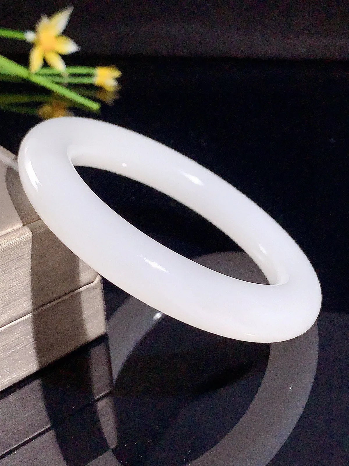 冰白色，圈口57宽13新疆和田玉57圈口羊脂白玉肥圆条手镯，略带一个黑点，料子细度好，品质好