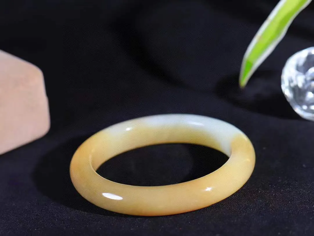 [温润如玉.手镯]

精品和田玉糖白玉手镯。玉质温润细腻 油性十足 手感舒适，高华雅逸，线条流畅，简约大气，美自天成，素雅高贵。佩戴于腕间，婉约之美，举手投足间透出那份低调奢华。重51.6克 内径55.5mm尺寸11.6-9.1mm781201814T