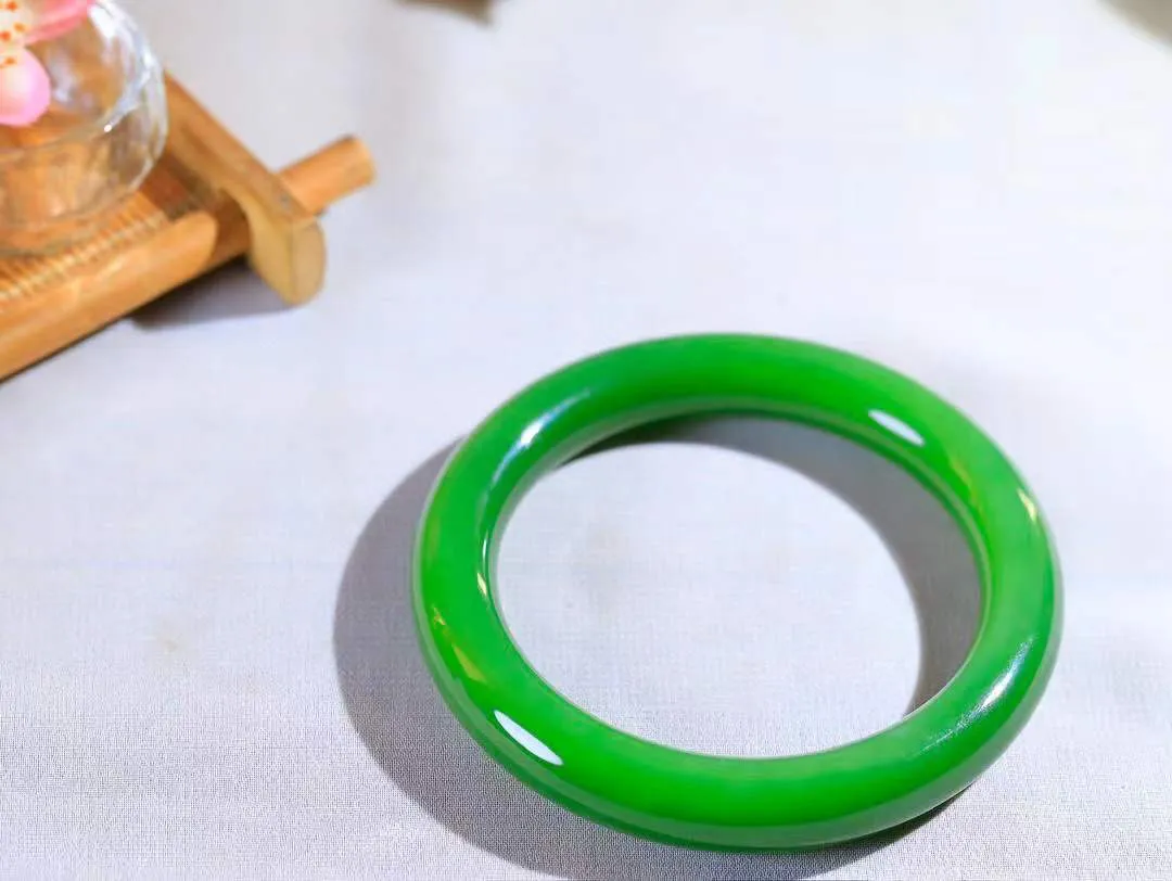 【悠悠芳华.镯】

典藏级臻品和田玉碧玉猫眼圆条手镯 玉质温润 青葱岁月，尽收腕中，婉转流畅，凝岁月悠长。盈一眸恬淡，挽一抹绿意。重63.6克 内径58.5mm尺寸11.5-10.8mm   861201855A