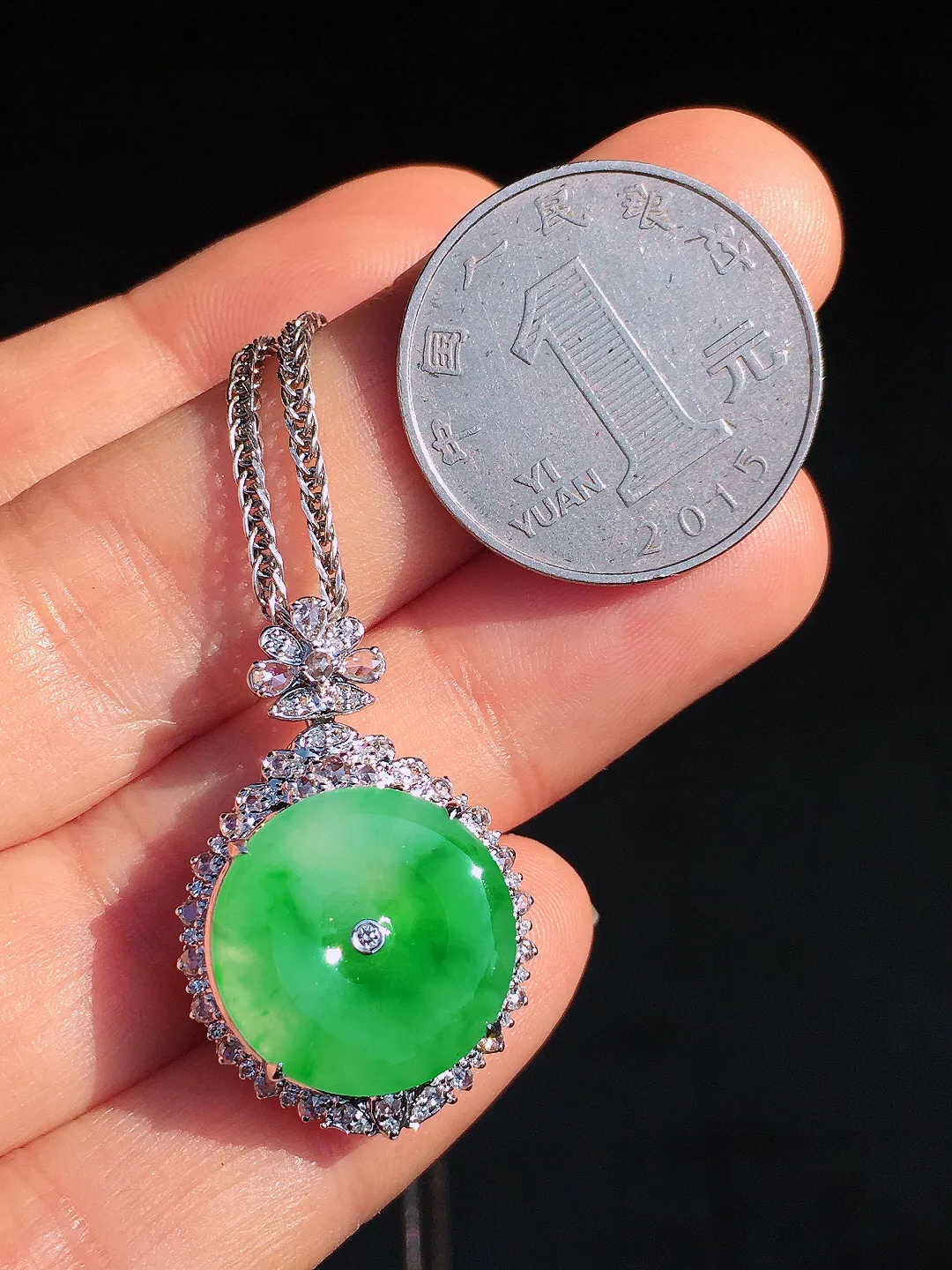阳绿平安扣吊坠，色泽艳丽，玉质细腻，荧光感超
强，饱满圆润，尽显优雅气质，18k
金豪华镶嵌