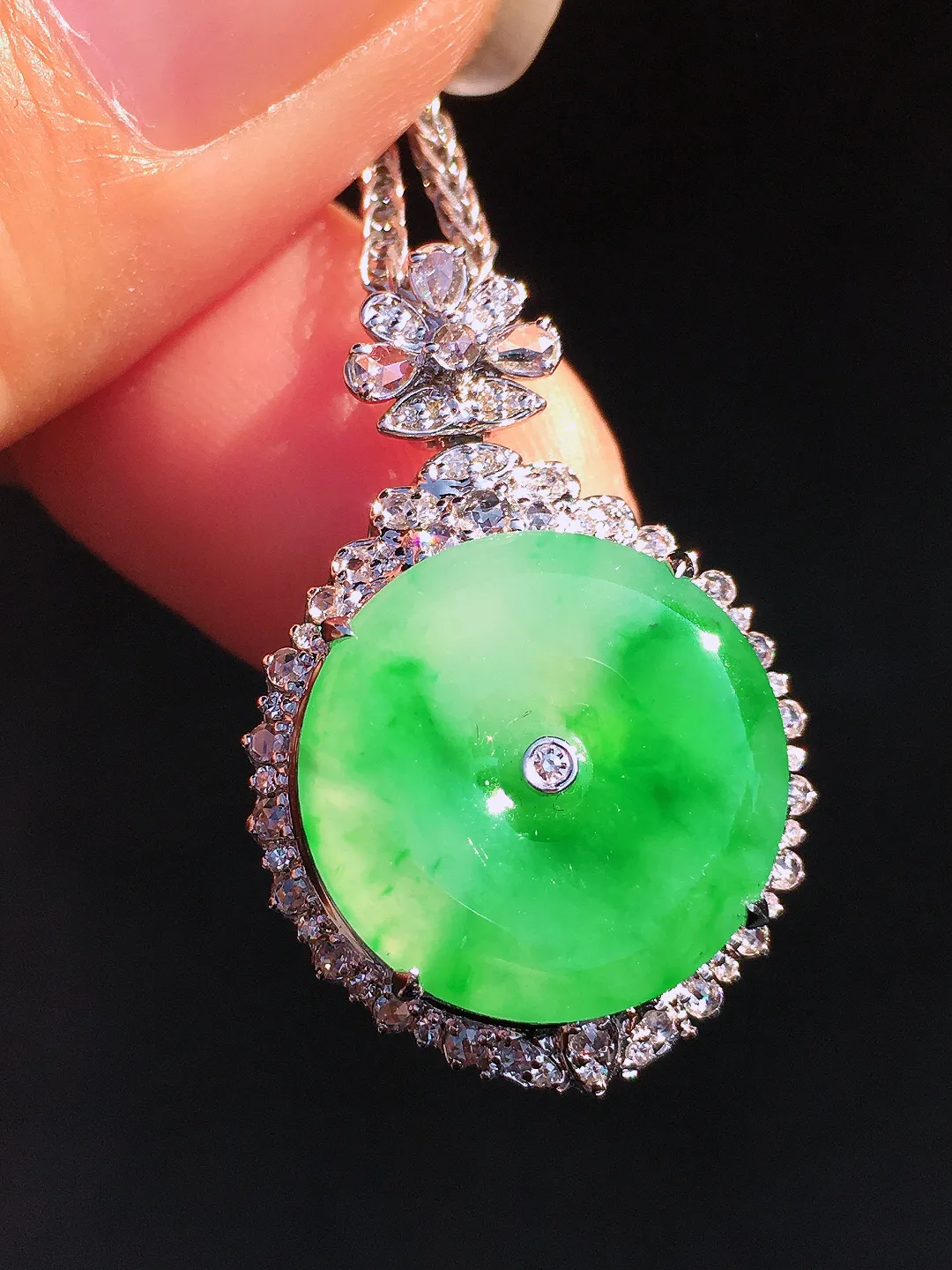 阳绿平安扣吊坠，色泽艳丽，玉质细腻，荧光感超
强，饱满圆润，尽显优雅气质，18k
金豪华镶嵌