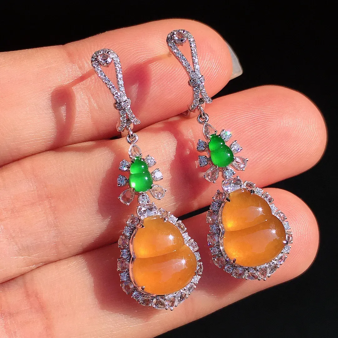 黄翡葫芦耳坠，色泽均匀艳丽，玉质细腻，荧光感超
强，饱满圆润，尽显优雅气质，18k
金豪华镶嵌